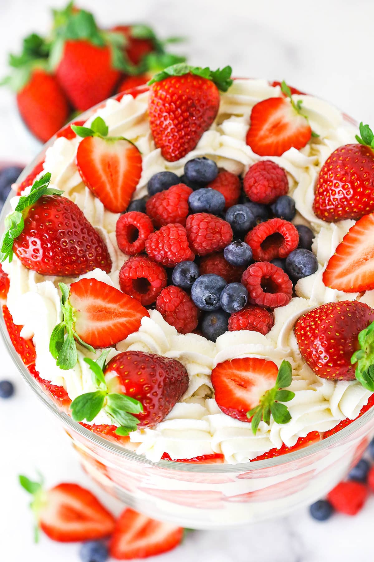 This trifle recipe is the best summer dessert! It's filled with layers of angel food cake, pudding, strawberries, blueberries & raspberries. The top of a trifle decorated with strawberries, raspberries and blueberries