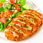 crispy buffalo chicken on white plate with salad