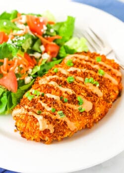 crispy buffalo chicken on white plate with salad