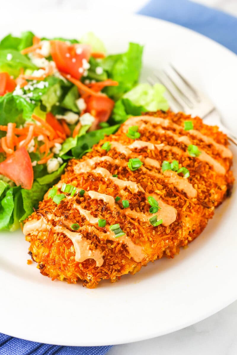 Crispy Buffalo chicken and salad on white plate