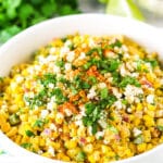 mexican street corn salad in a white bowl on a teal and white napkin