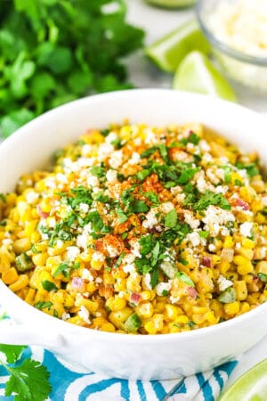 mexican street corn salad in a white bowl on a teal and white napkin