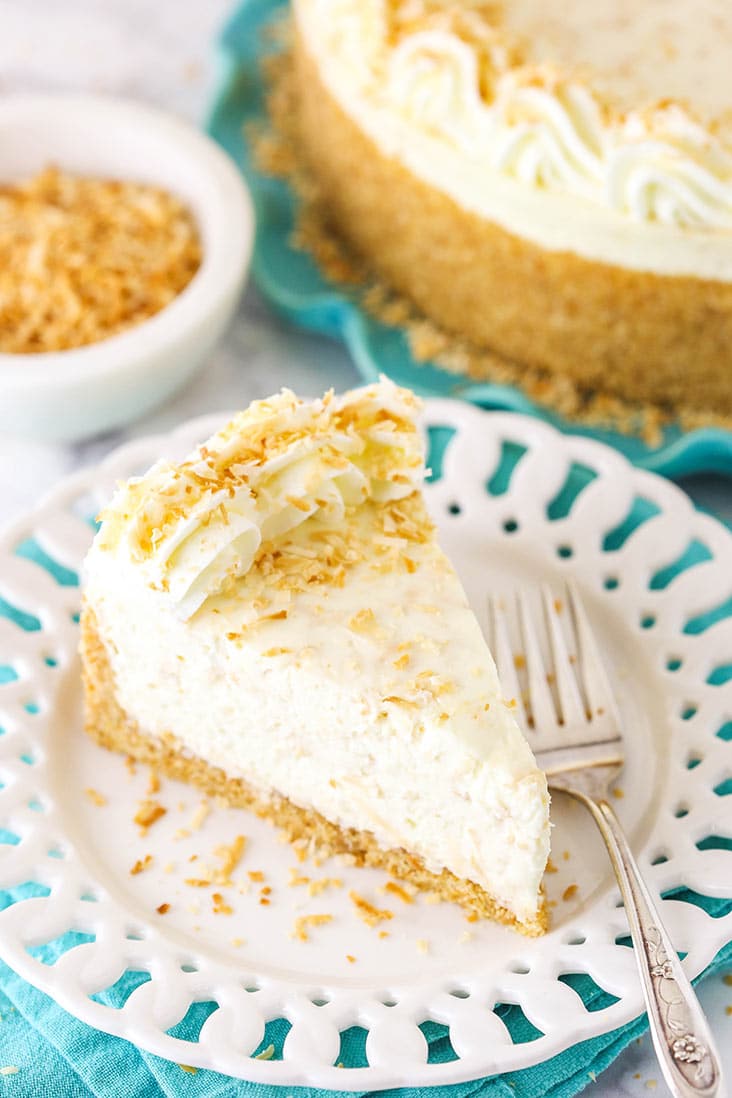 A slice of toasted coconut cheesecake with coconut whipped cream