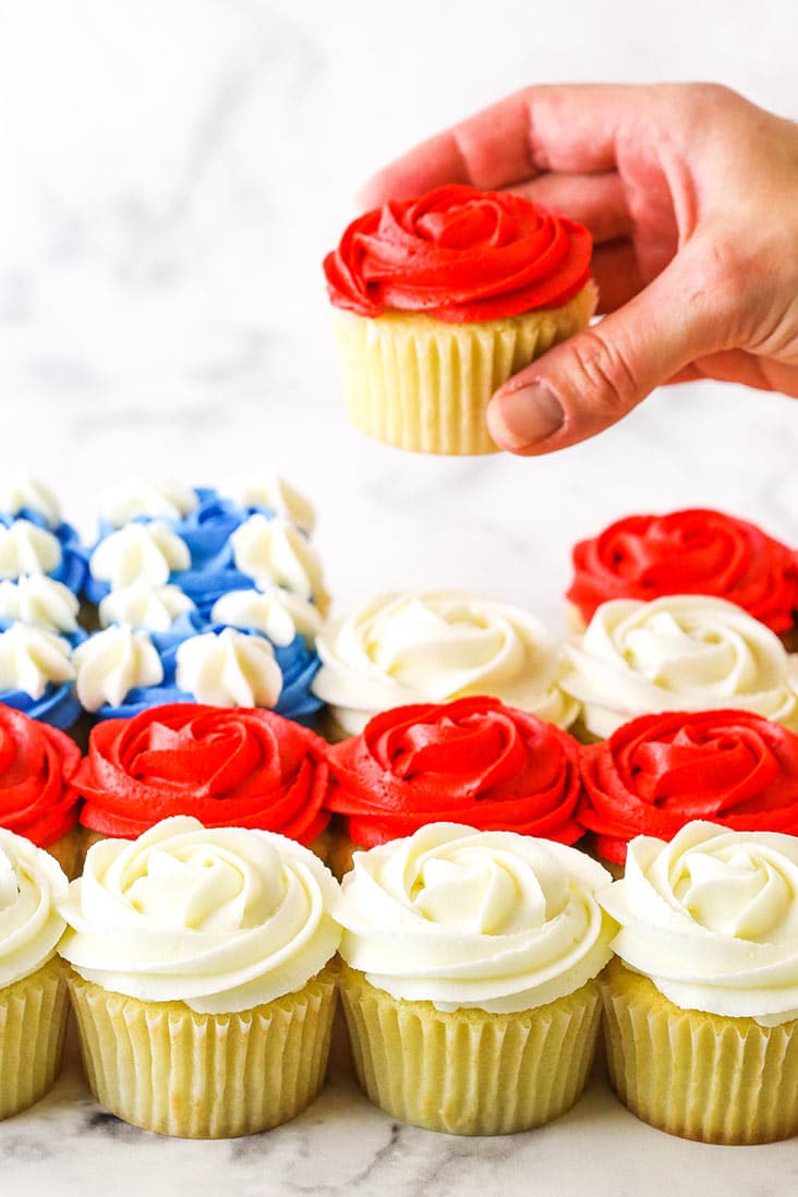 hand lifting a red cupcake out of flag formation