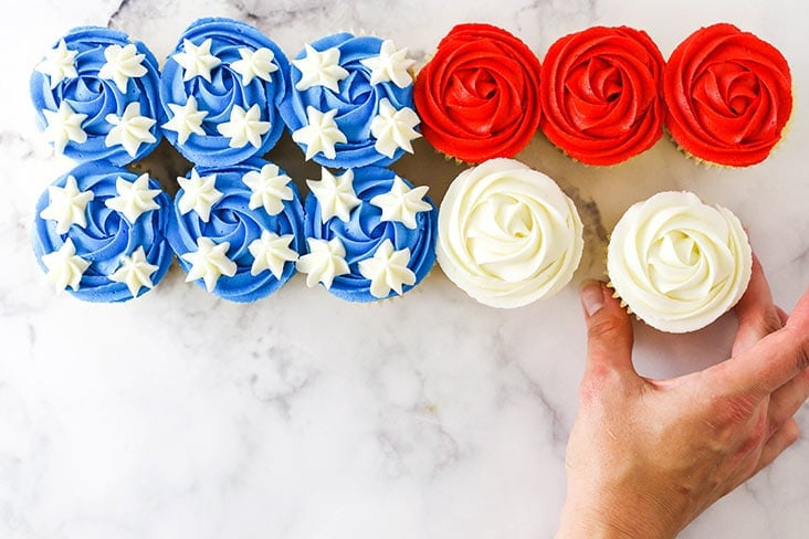 hand putting together the flag cupcake cake