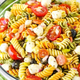 A bowl of Italian pasta salad with fresh mozzarella, tomato, olives, and pepperoni
