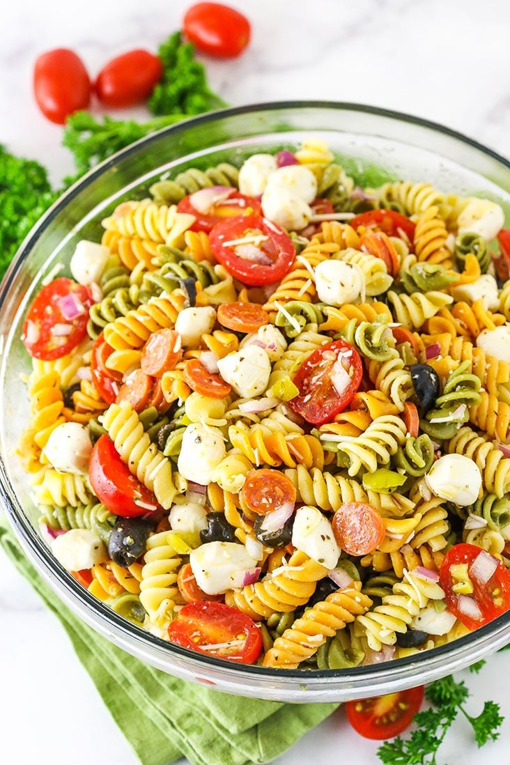 A bowl of Italian pasta salad with fresh mozzarella, tomato, olives, and pepperoni