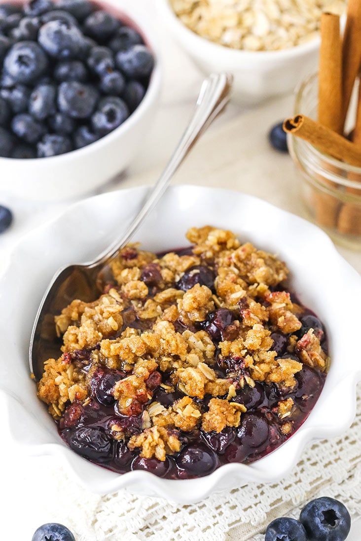 blueberry crisp in a white ruffled bowl