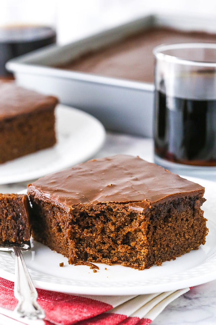 slice of coca cola cake on a white plate with a bite taken