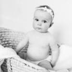 B&W photo of McKenzie sitting in a basket