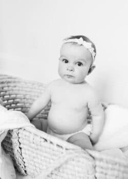 B&W photo of McKenzie sitting in a basket