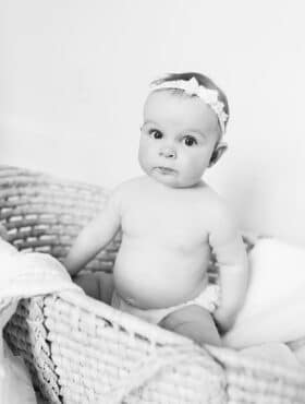 B&W photo of McKenzie sitting in a basket