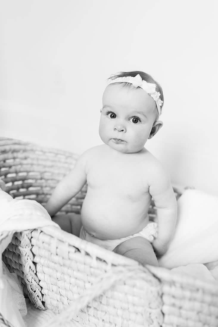 B&W photo of McKenzie sitting in a basket