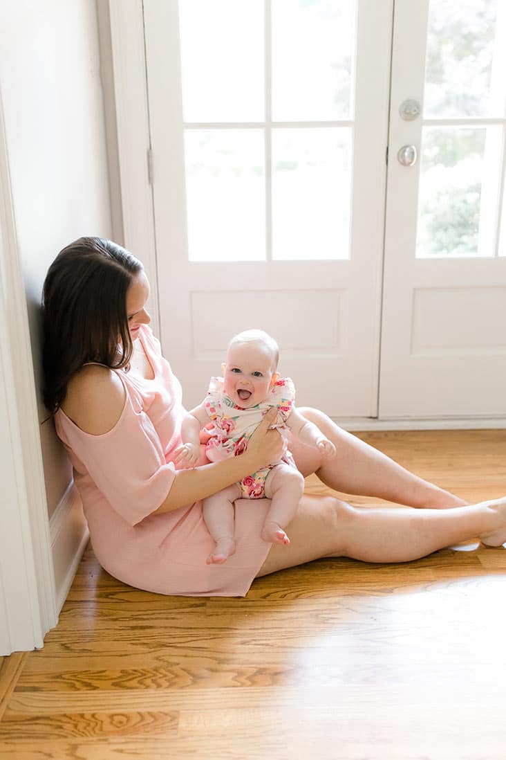 Lindsay sitting by doorway with McKenzie smiling on lap