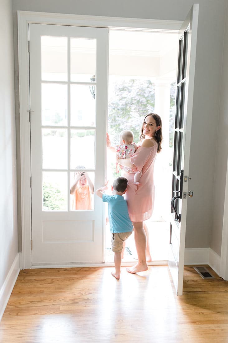 Lindsay walking through an open front door with the kids