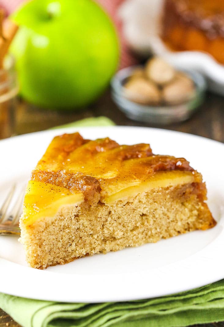 A slice of apple upside down cake on a white plate