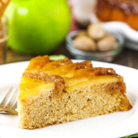 A slice of apple upside down cake on a white plate