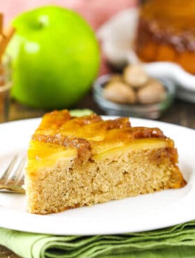 A slice of apple upside down cake on a white plate