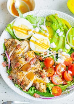 herb chicken cobb salad with dressing in white bowl