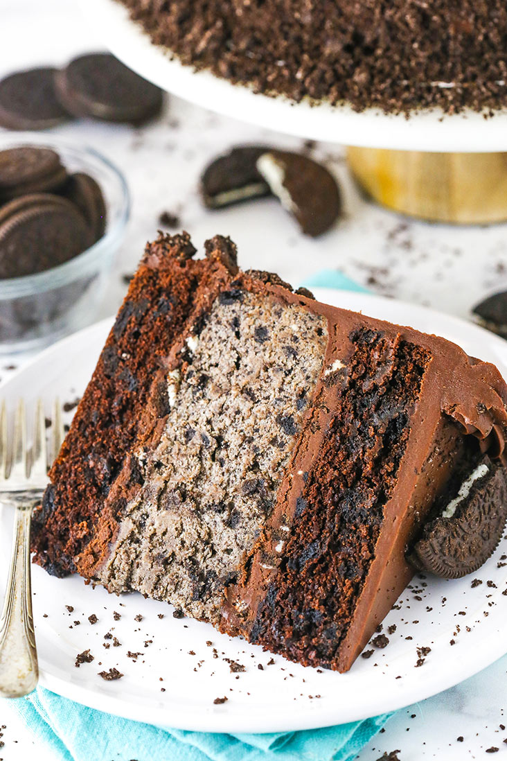 A slice of Oreo cheesecake cake on a white plate