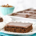 A square slice of chocolate sheet cake on a white plate