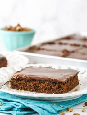 A square slice of chocolate sheet cake on a white plate