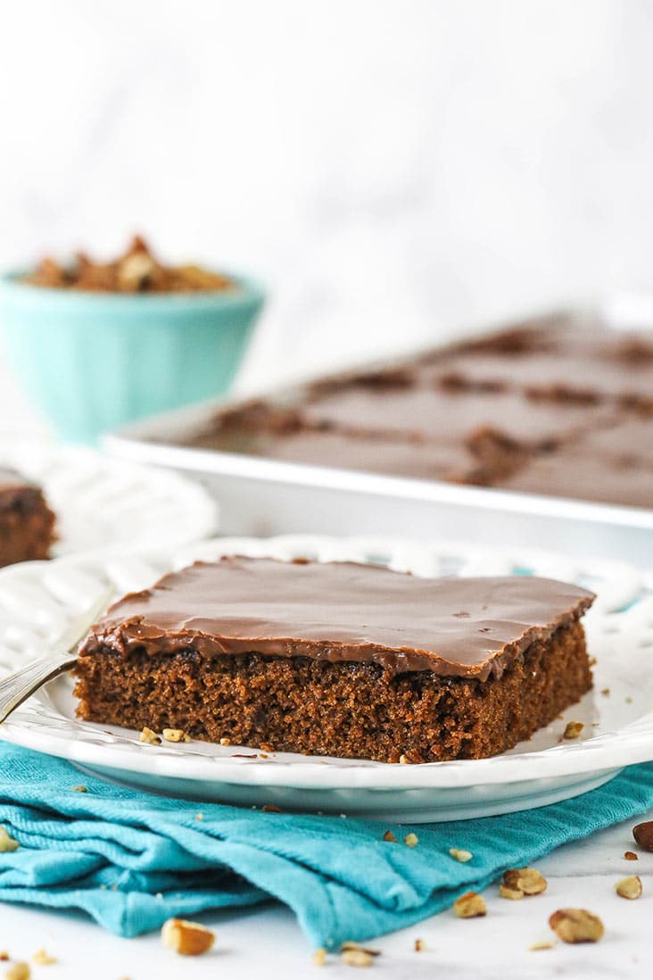 A square slice of chocolate sheet cake on a white plate