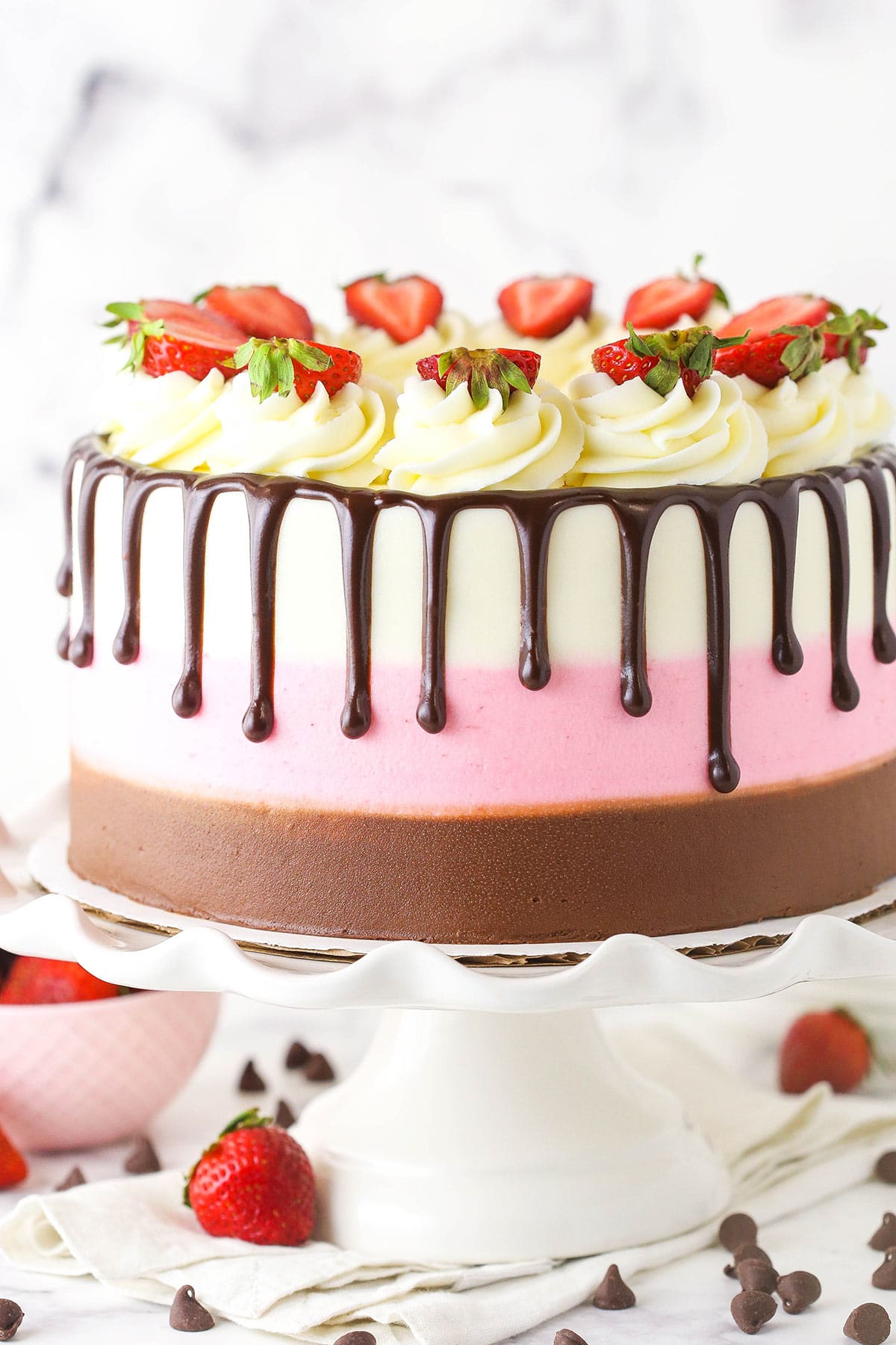 A close-up shot of a neapolitan cake with chocolate, vanilla and strawberry buttercream frosting