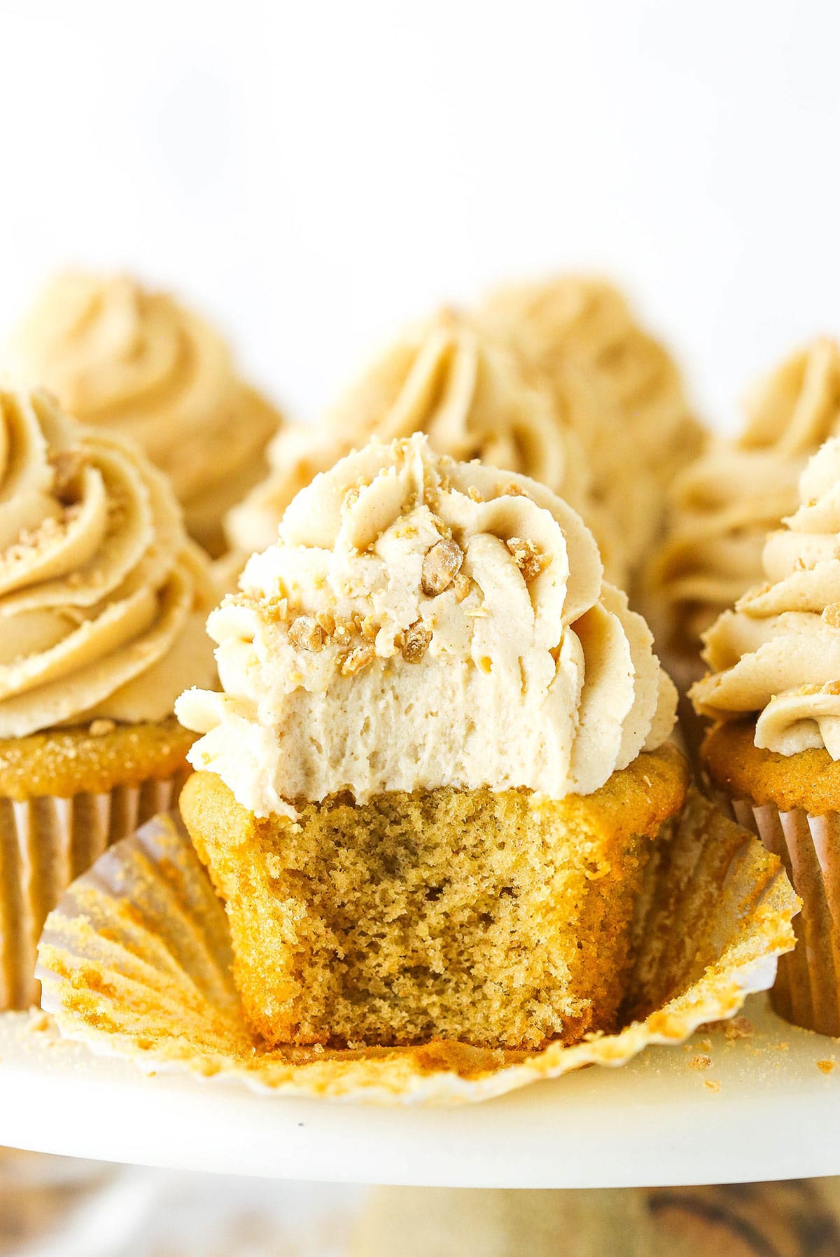 An unwrapped peanut butter cupcake with a bite taken out to reveal the fluffy interior