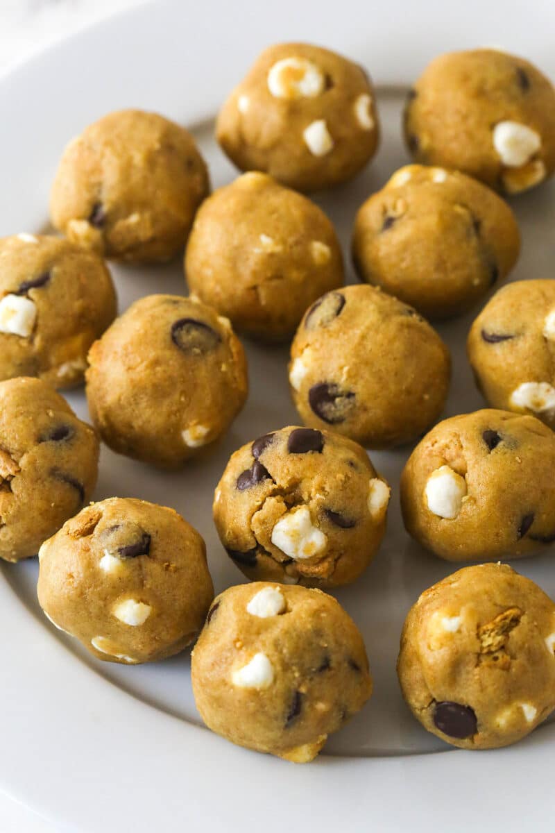 Every bite of these s’mores cookies is loaded with rich chocolate, gooey marshmallows, and sweet graham crackers. Balls of s'mores cookie dough