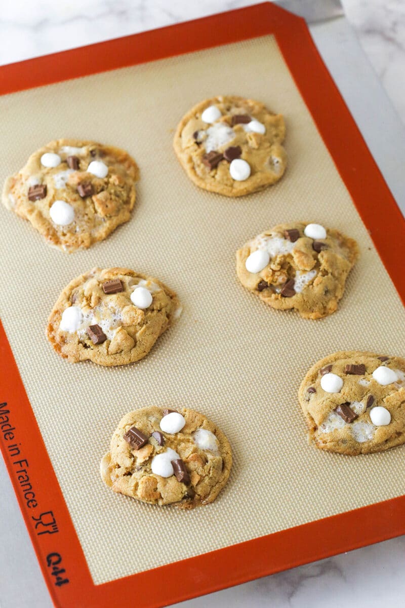 Every bite of these s’mores cookies is loaded with rich chocolate, gooey marshmallows, and sweet graham crackers. Freshly baked s'mores cookies on a cookie sheet