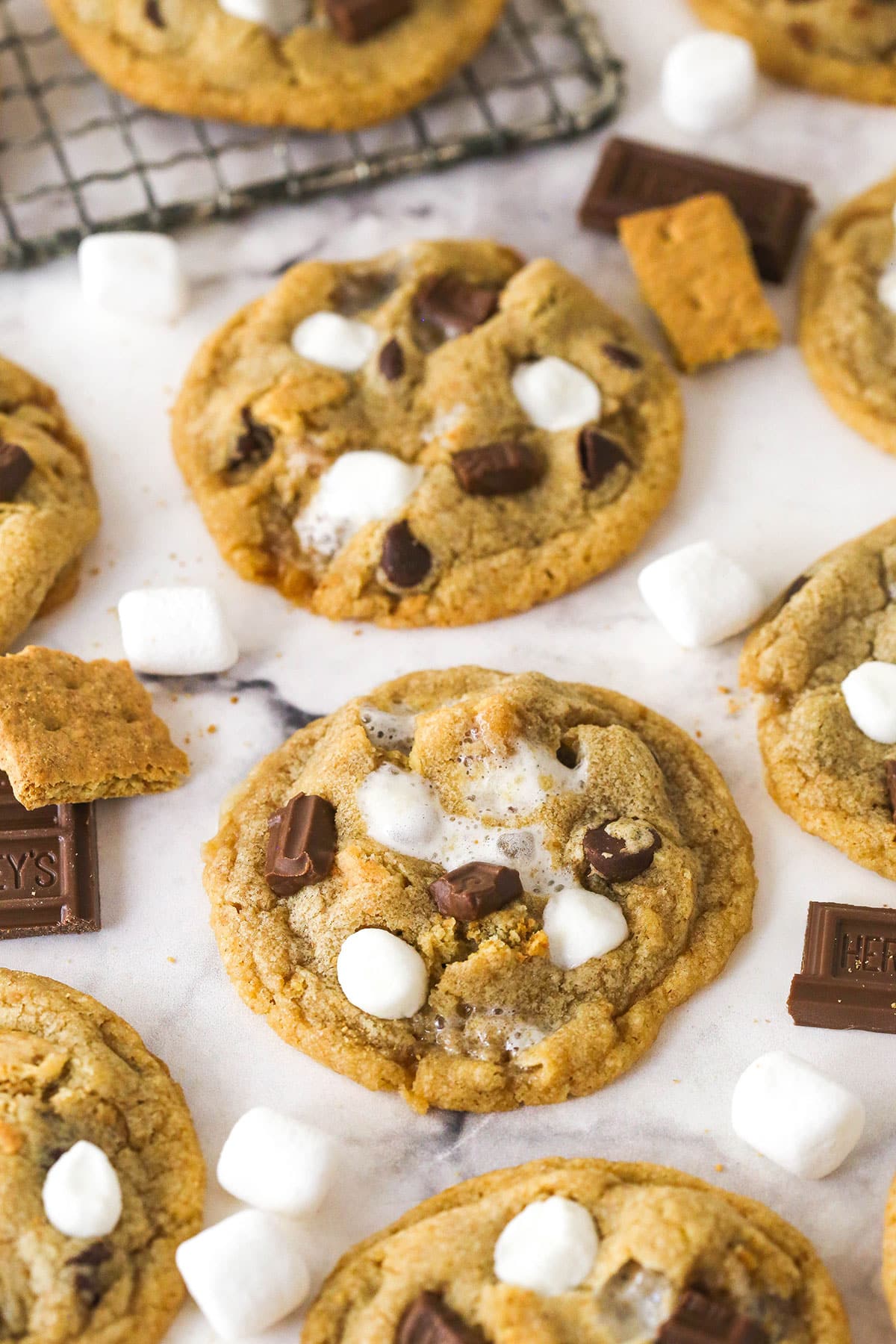Every bite of these s’mores cookies is loaded with rich chocolate, gooey marshmallows, and sweet graham crackers. Close up of s'mores cookies on a marble countertop
