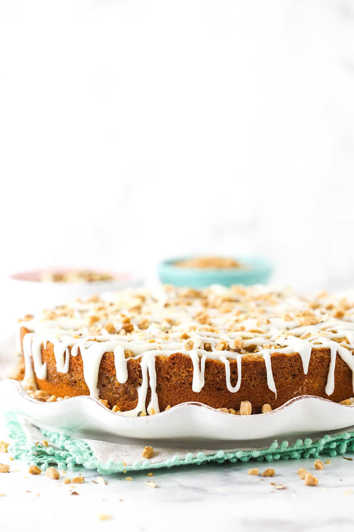 A glazed breakfast layer cake on a cake stand over three stacked placemats