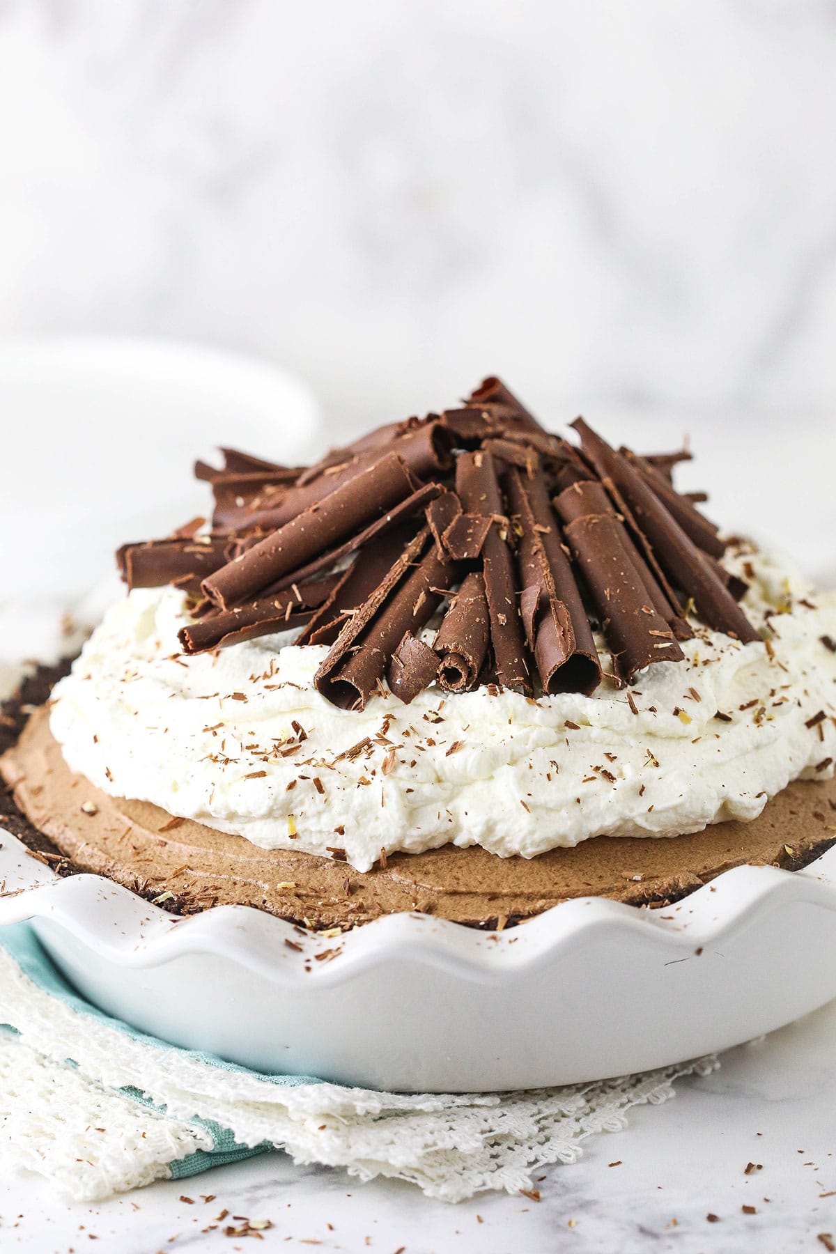 french silk pie with chocolate curls on top on a teal napkin with lace border