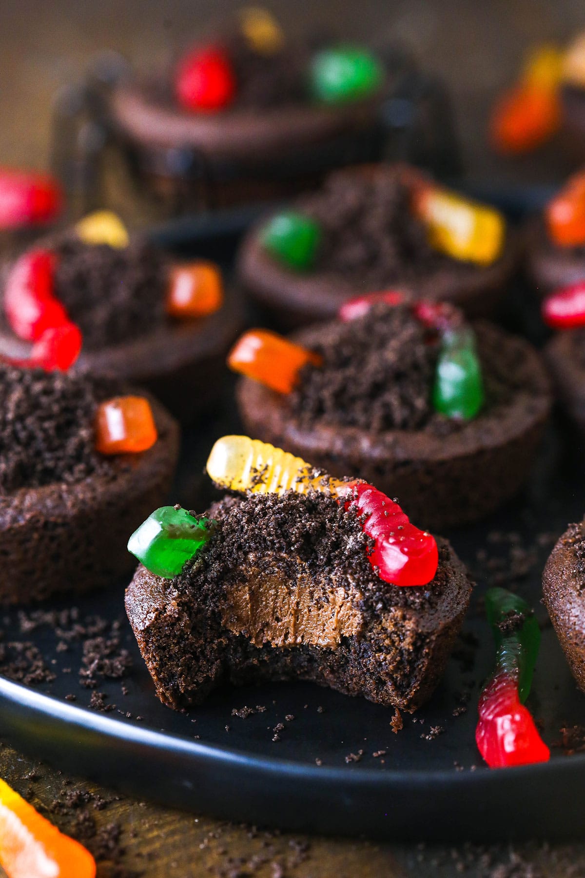 A dirt cookie cup with a bite taken out to reveal the creamy buttercream filling