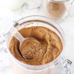 A jar filled with hot chocolate mix on top of a black and white marble counter