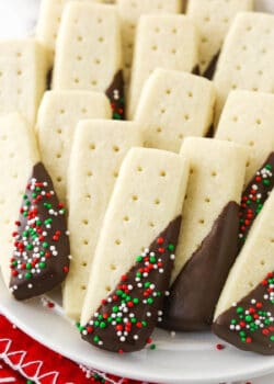 A close-up shot of chocolate covered shortbread cookies arranged on a white plate