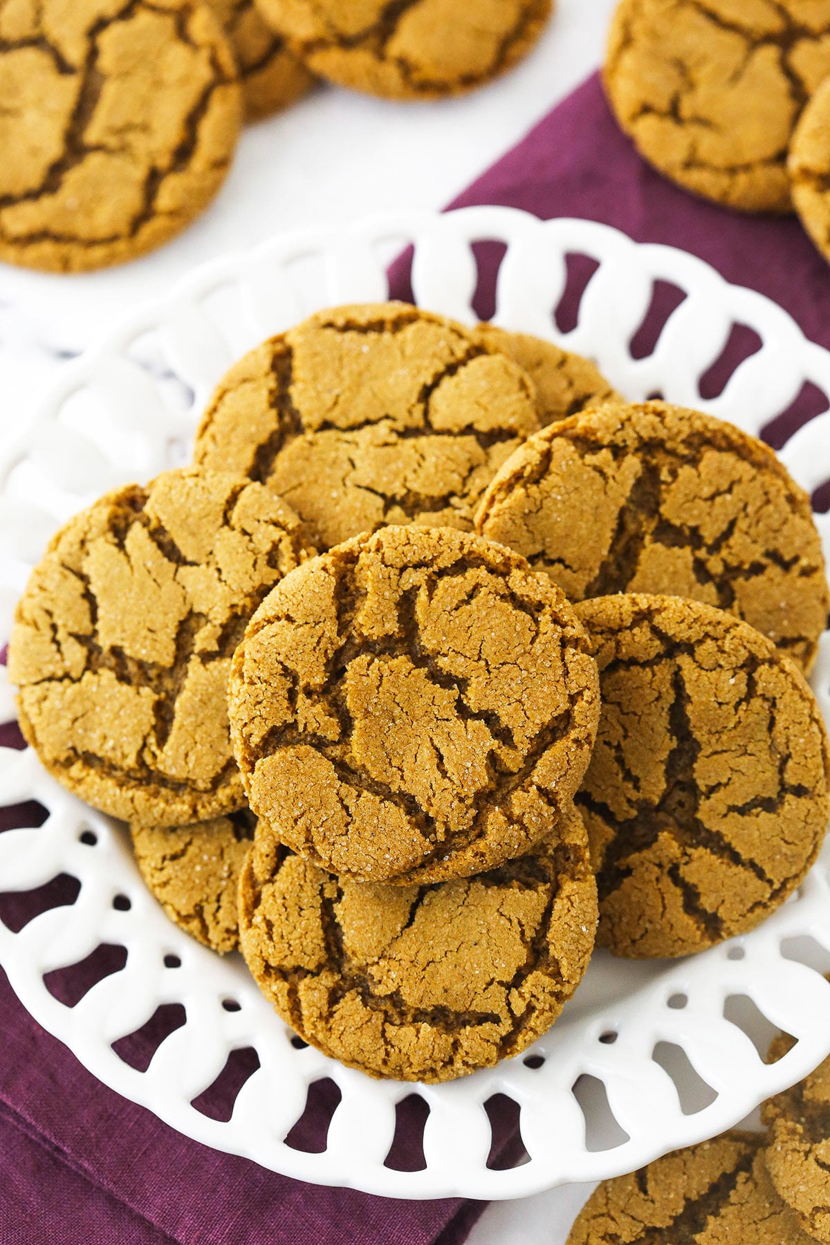 A white plate full of homemade molasses cookies on a marble countertop