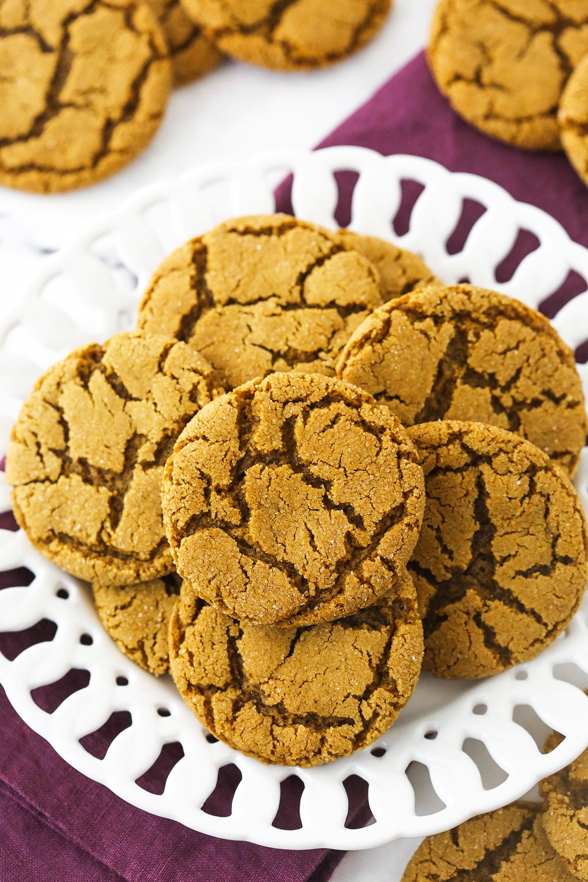 A white plate full of homemade molasses cookies on a marble countertop.