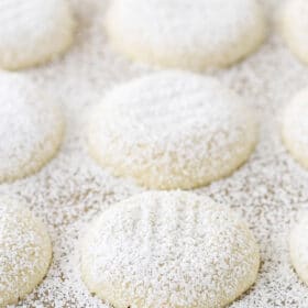A close-up shot of soft vanilla butter cookies coated in powdered sugar