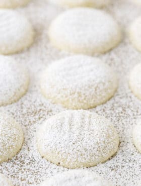 A close-up shot of soft vanilla butter cookies coated in powdered sugar