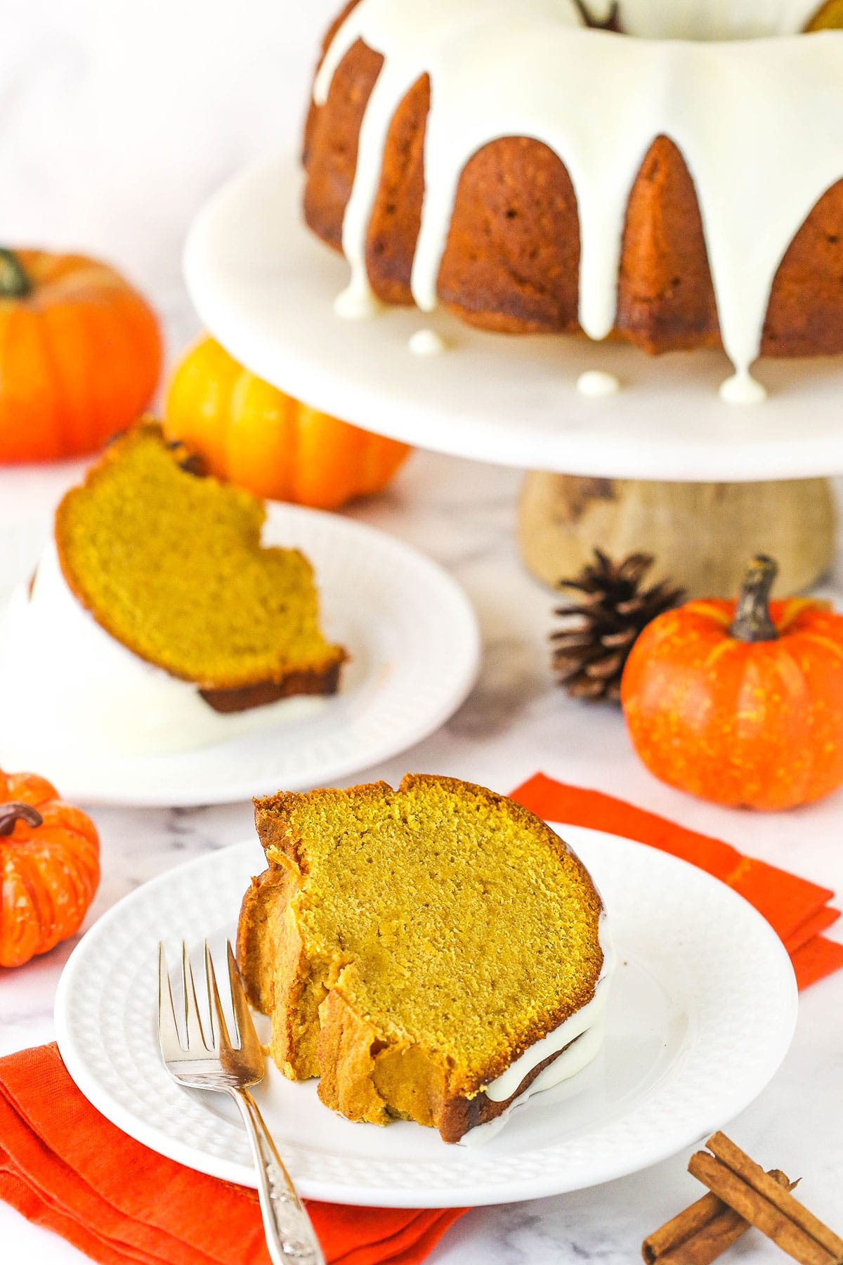 Two slices of pumpkin pound cake on white plates.