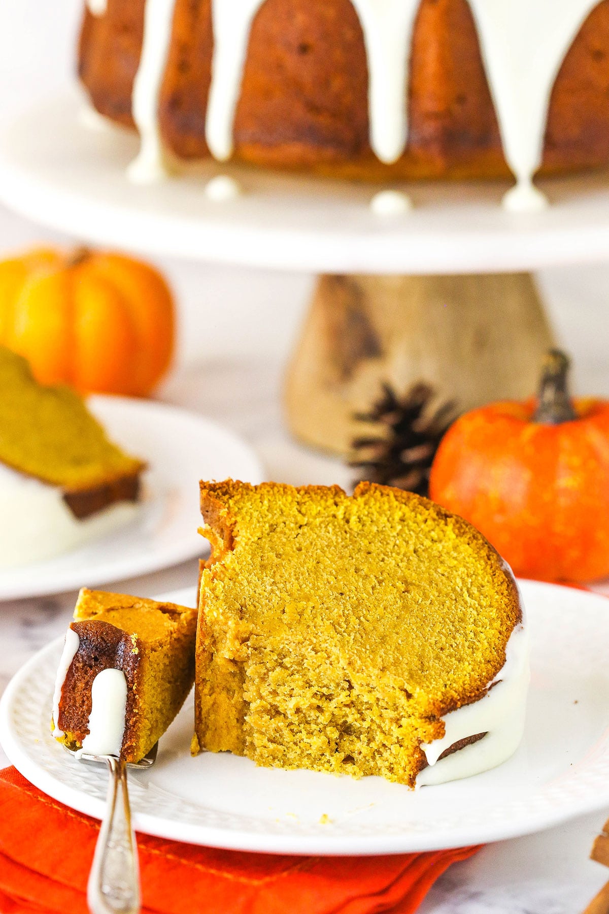 Pumpkin pound cake slice on white plate with a bite taken.