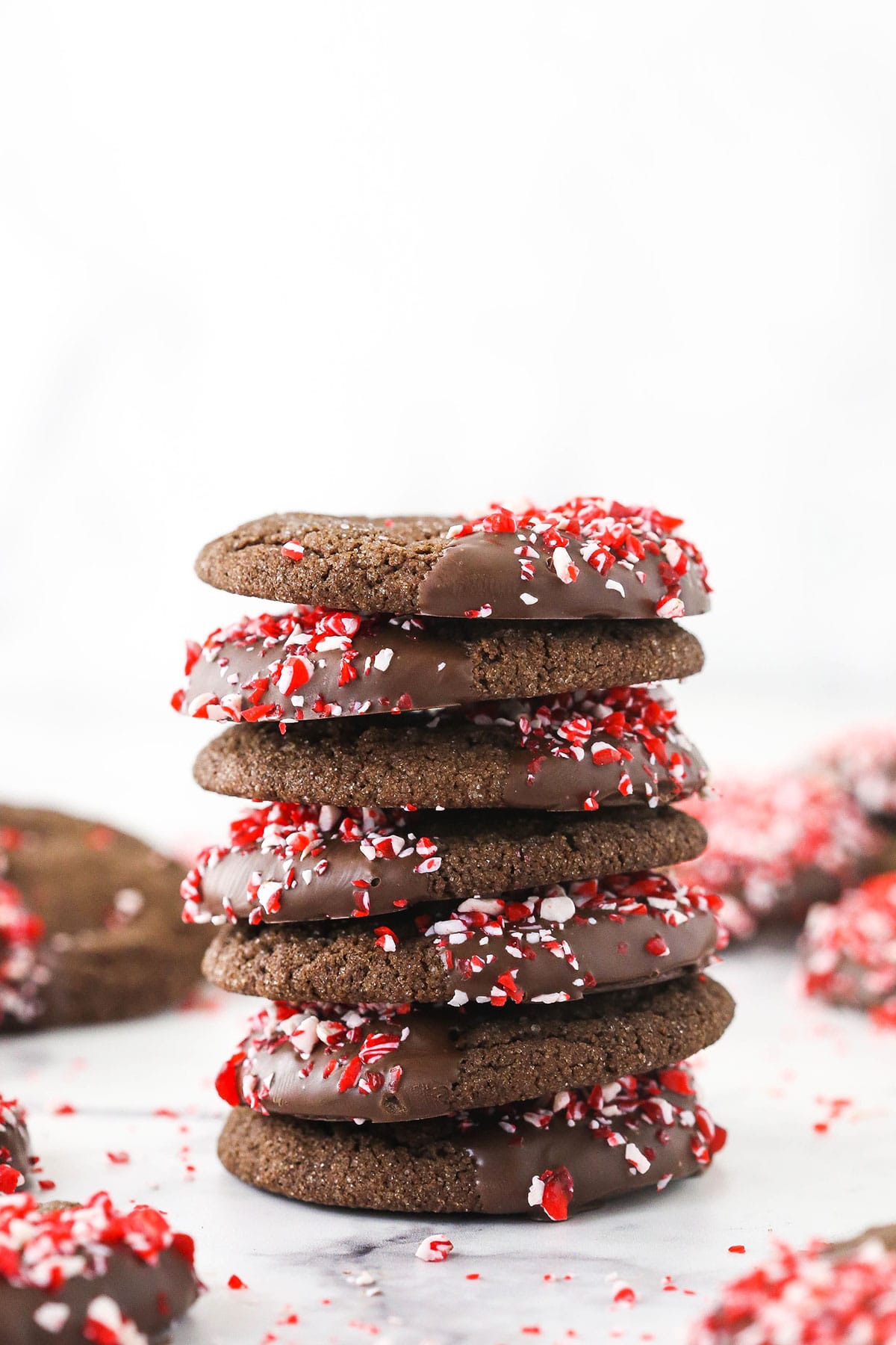 A stack of seven chocolate Christmas sugar cookies on a white kitchen countertop