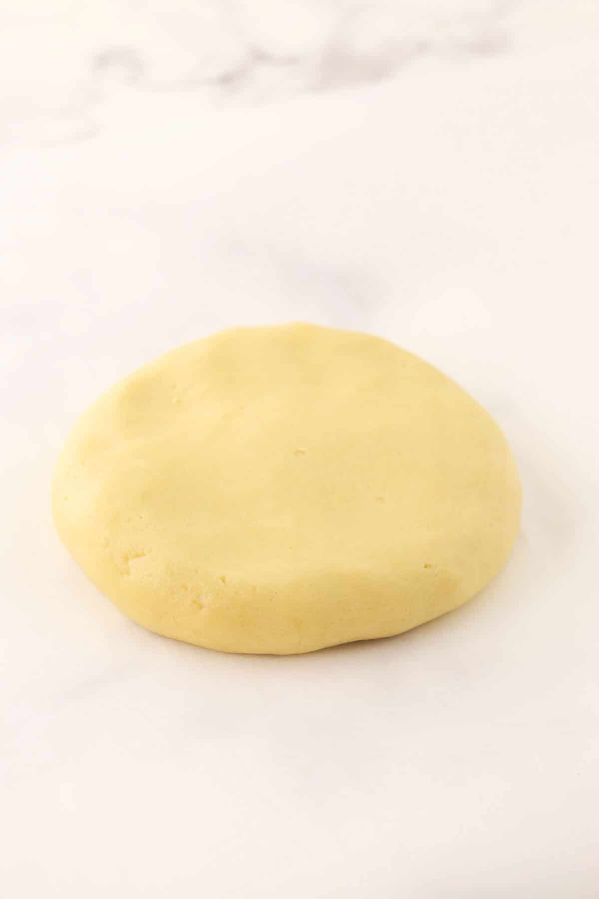 A smooth disc of dough on a granite surface