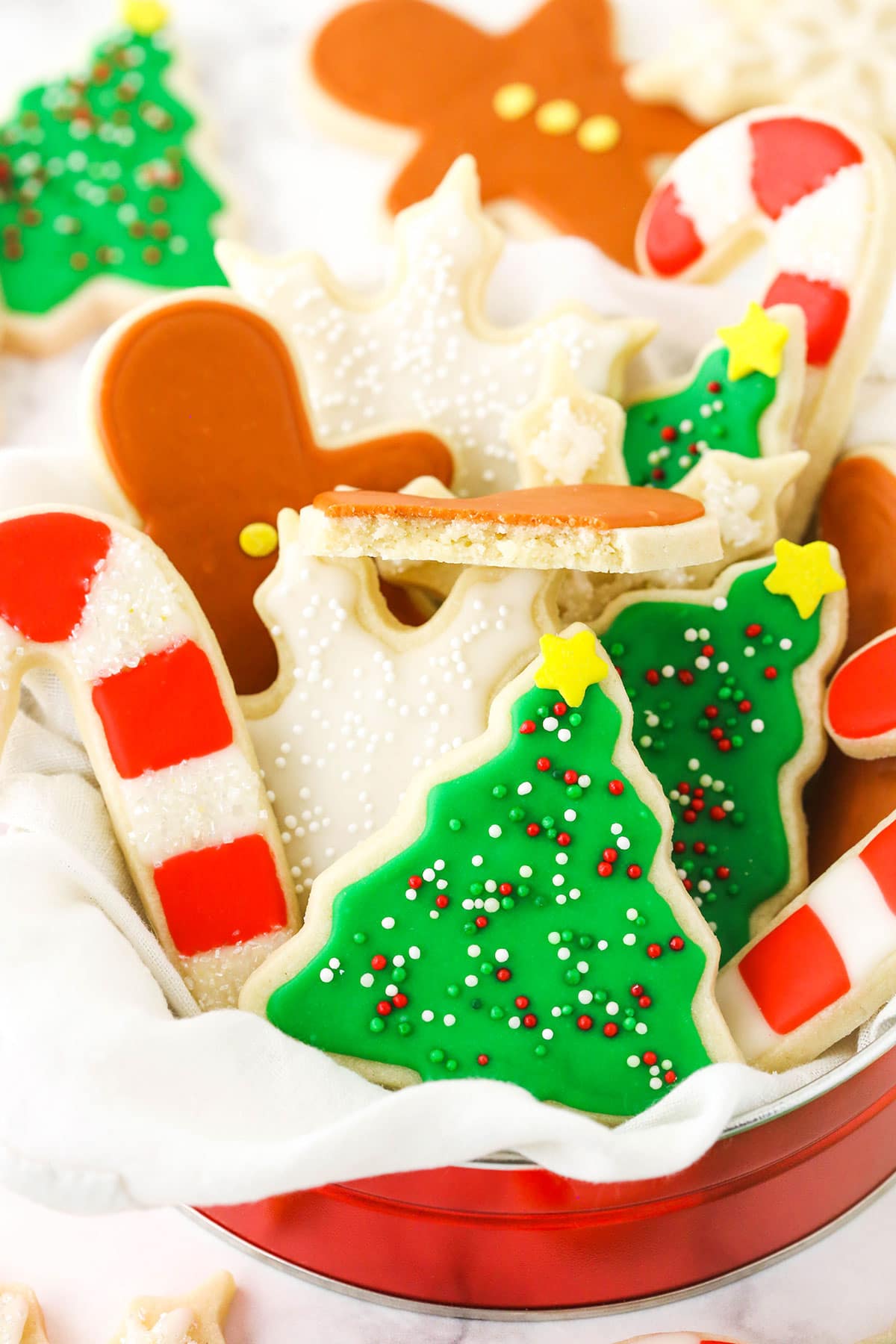 A close-up shot of holiday-themed cookies in a small tin.