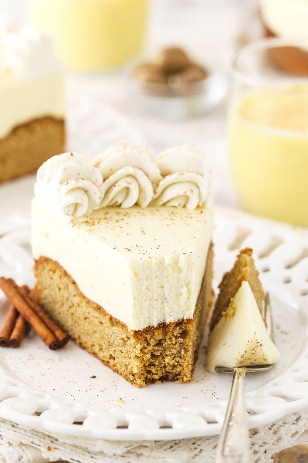 A serving of eggnog blondie cheesecake on a plate with one bite on a metal fork
