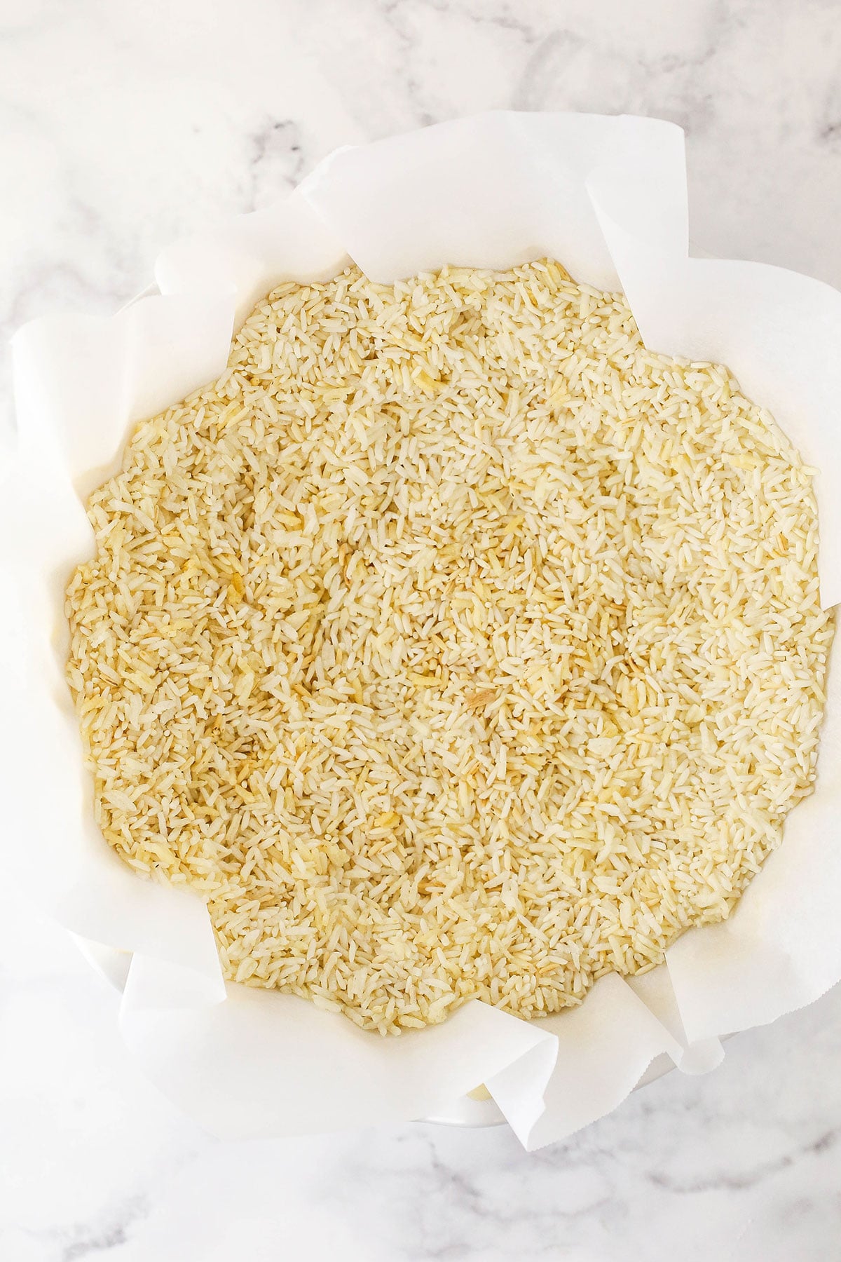overhead image of rice within the parchment paper in a pie plate