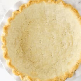 Overhead view of a fully baked pie crust in a white pie plate.