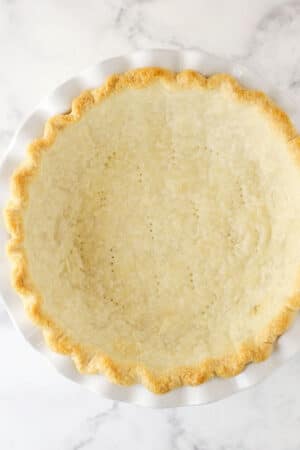 fully baked pie crust in white pie plate